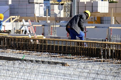 Construction work on the foundations of a large apartment building. The construction workers are