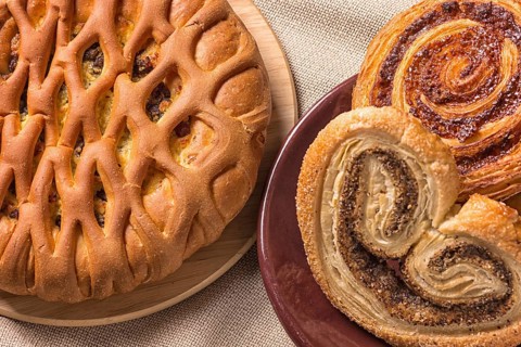 Sweet buns on a wooden board and linen tablecloth
