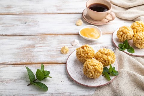 Traditional Tatar candy chak-chak made of dough and honey with cup of coffee on a white wooden