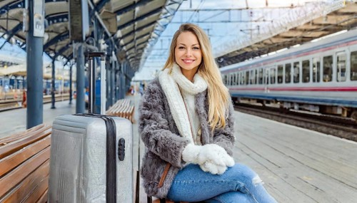 AI generated, A young blonde woman wants to travel and waits for the train at the station, 20, 25,