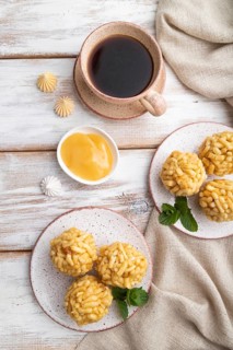 Traditional Tatar candy chak-chak made of dough and honey with cup of coffee on a white wooden