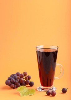 Glass of red grape juice on orange background. Morninig, spring, healthy drink concept. Side view,