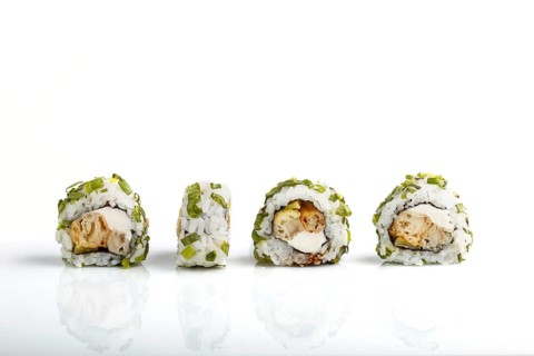 Four Japanese maki sushi rolls in a row with cream cheese and onion isolated on white background