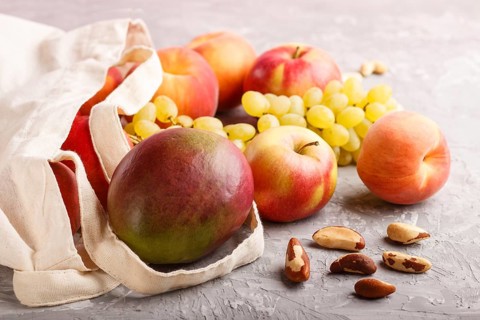 Fruits in reusable cotton textile white bag. Zero waste shopping, storage and recycling concept,