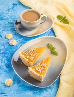 Two pieces of traditional american pumpkin pie with cup of coffee on a blue concrete background and
