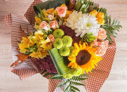 Bouquet of alstroemeria, sunflower, roses, chrysanthemum on a wooden background. floristic