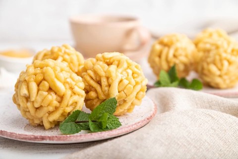 Traditional Tatar candy chak-chak made of dough and honey with cup of coffee on a white wooden