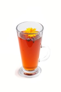 Glass of herbal tea with calendula and hyssop isolated on white background. Morninig, spring,