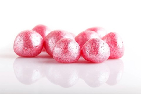 Heap of pink hard sugar candies isolated on white background