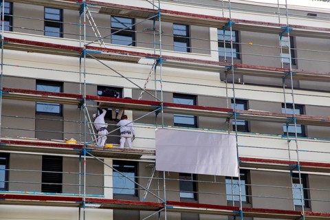 Painter painting the facade of a new apartment building