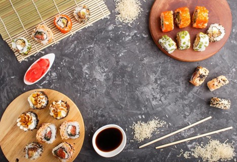 Different kinds of Japanese maki sushi rolls with salmon, sesame, cheese, roe and chopsticks, soy