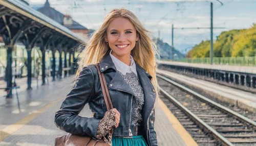AI generated, A young blonde woman wants to travel and waits for the train at the station, 20, 25,