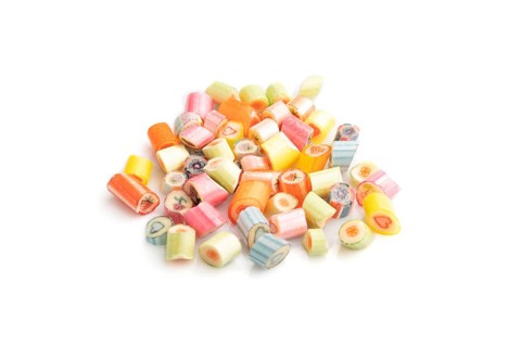 Heap of multicolored caramel candies isolated on white background. close up, side view