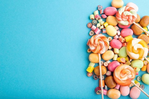 Various caramel candies on blue pastel background. copy space, top view, flat lay