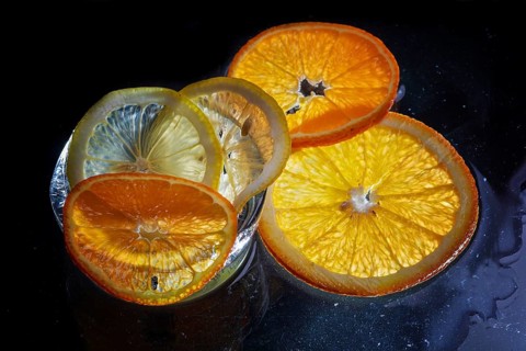 Transparent slices of fresh oranges and lemons on the glass with ice