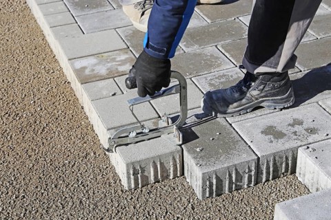 Workers lay paving stones