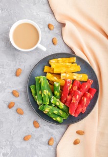 Set of various traditional turkish delight (rahat lokum) in blue ceramic plate with cup of coffee