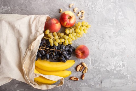 Fruits in reusable cotton textile white bag. Zero waste shopping, storage and recycling concept,