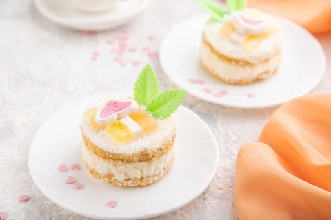 Decorated cake with milk and coconut cream with cup of coffee on a gray concrete background and