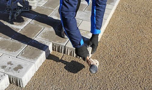 Workers lay paving stones