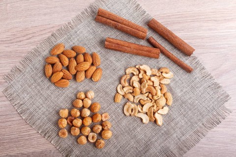Cinnamon, almonds, hazelnuts, cashew on a linen napkin. Still life. Closeup