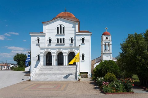 An imposing whitewashed church with a red roof and bell tower on a sunny day, Greek Orthodox Church