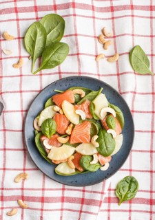 Fresh salmon with pineapple, spinach and cashew on a gray concrete background. Top view, flat lay,