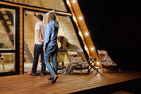 A couple returns to tiny log cabin late at night after a walk outdoors