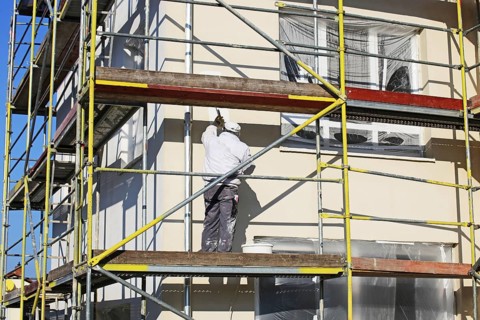Painter painting the facade of a new residential building (Mutterstadt development area,
