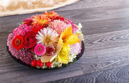 Floral arrangement of autumn flowers on a plate. dahlia, zinnia, rose, orchid, maple leaves. copy