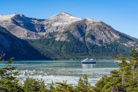 Cruise ship Stella Australis anchored between ice floes in Pia Bay in front of the Pia Glacier,