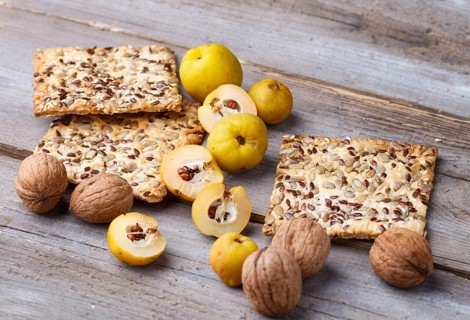Biscuits with flax, sesame and sunflower seeds and yellow quince fruit on a rustic wooden