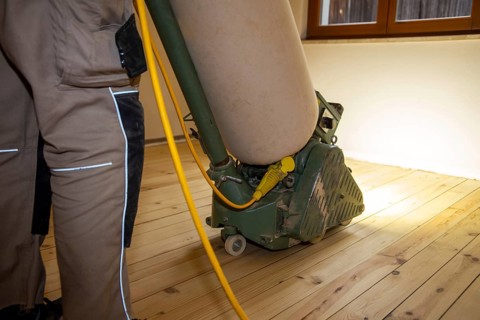 Craftsmen professionally sanding a plank floor