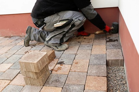 Worker lays paving stones