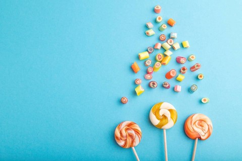 Various caramel candies on blue pastel background. copy space, top view, flat lay