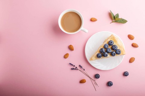 Homemade layered Napoleon cake with milk cream. Decorated with blueberry, almonds, walnuts,