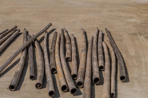 Weathered cracked bamboo poles laying on concrete driveway in South Korea