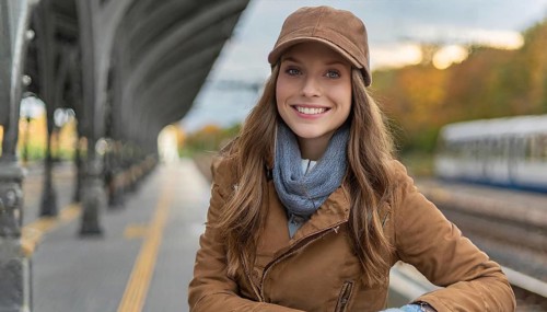 AI generated, A young blonde woman wants to travel and waits for the train at the station, 20, 25,