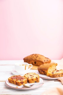 Homemade cake with raisins, almonds, soft caramel on a white and pink background. Side view,