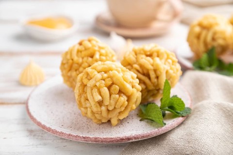 Traditional Tatar candy chak-chak made of dough and honey with cup of coffee on a white wooden