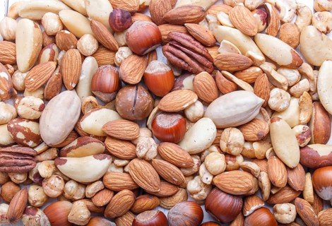 Background and texture made from different kinds of nuts. hazelnut, brazil nut, almond, pumpkin