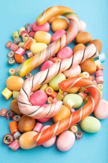 Various caramel candies on blue pastel background. close up, side view