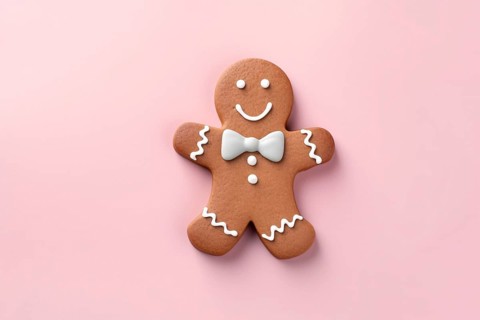 Christmas gingerbread man with bow tie on pink background. KI generiert, generiert AI generated