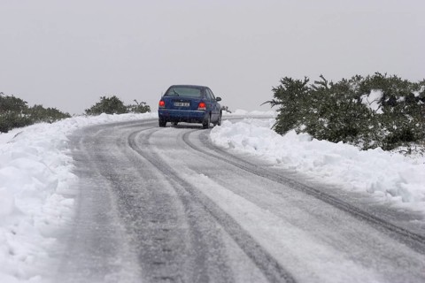 Blue rental car in the snow of the highest mountain Roque de los Muchachos altitude 2400 m, La
