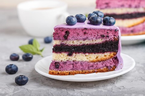 Homemade cake with souffle cream and blueberry jam with cup of coffee and fresh blueberries on a