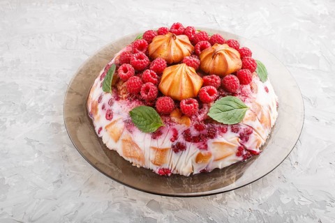 Homemade jelly cake with milk, cookies and raspberry on a gray concrete background. side view,