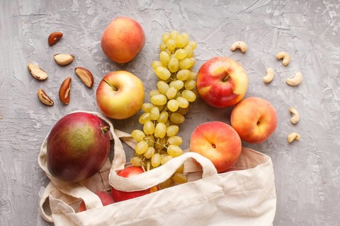 Fruits in reusable cotton textile white bag. Zero waste shopping, storage and recycling concept,