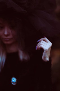 Close-up of a woman in soft focus with tulle fabric, set against a dark theme with subtle colors