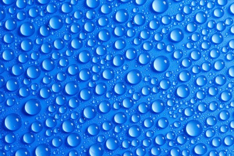 Many small water drops on a blue surface