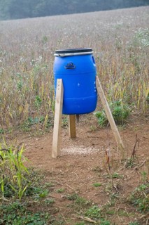Blue barrel tripod bird feeder in field, Ramsholt, Suffolk, England, United Kingdom, Europe